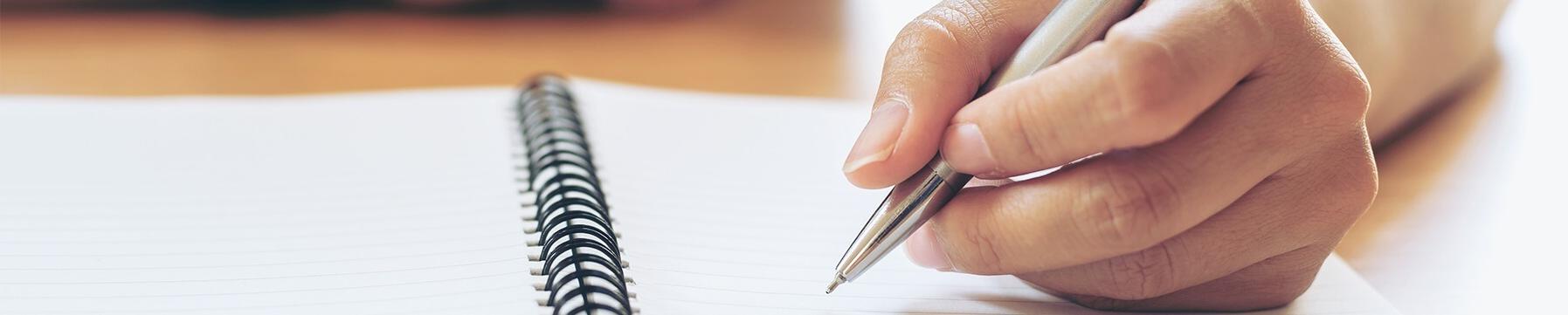 Student writes in spiral-bound notebook